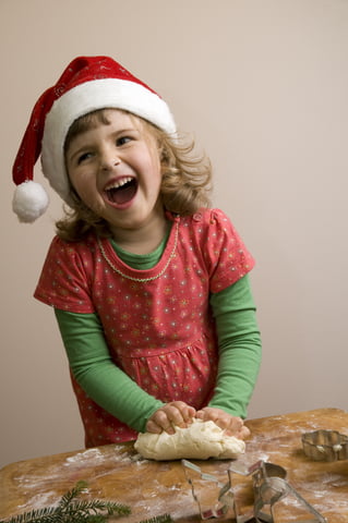 Girl in Santa hat cooking and laughing